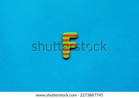 letter f on blue paper background 