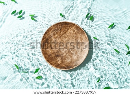 Beauty cosmetics product presentation scene made with wooden pedestal floating blue water. Top view backdrop.