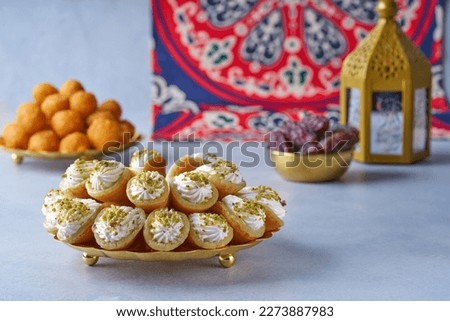 Arabian pancake Qatayef with qishta cream and pistachio . Traditional sweets with ramadan decor .                       