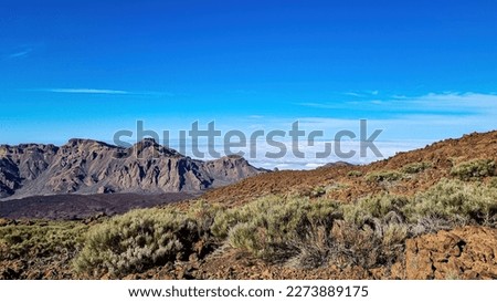 Hiking trail over volcanic terrain leading to summit of volcano Pico del Teide, Mount Teide National Park, Tenerife, Canary Islands, Spain, Europe. Valley and Atlantic Ocean is covered with clouds
