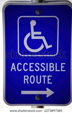 Tight Shot Of Metal Blue And White Handicap Accessible Route Sign Mounted On Pole