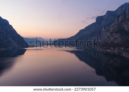 Beautiful aerial view of the famous Como Lake on purple sunset. Mountains reflecting in calm waters of the lake with Alp mountain range on the background. Lombardy, Italy. Royalty-Free Stock Photo #2273901057