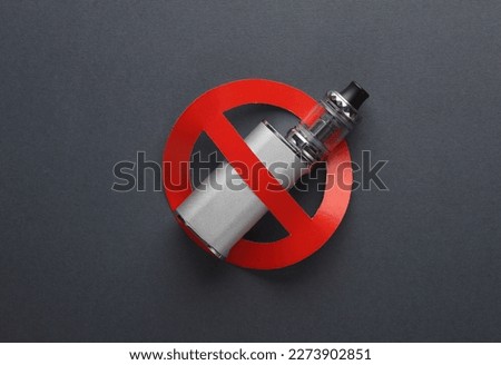 Vaping device with a prohibition sign on dark background. Smoking ban Royalty-Free Stock Photo #2273902851