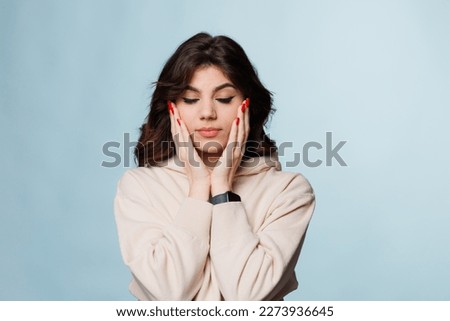 Beautiful Young Woman with closed eyes, beauty skin healthy face close up isolated on blue background.Cosmetology ,beauty and spa. Girl washes and cleans her face.