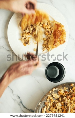 Mans hand over the plate with fall open chicken pie with celery, onions, chicken and creamy sauce. Motion blurred.
