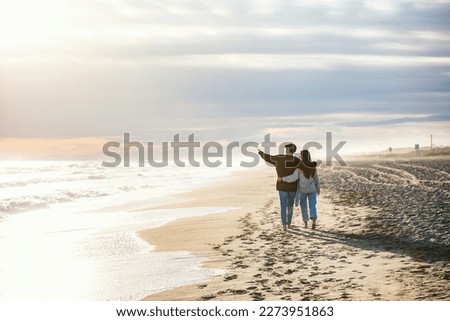 Portrait of beautiful young couple in love walking together in a cold winter day on the beach. Royalty-Free Stock Photo #2273951863