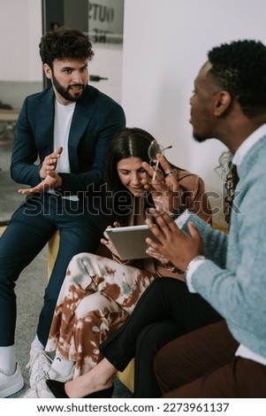 A photo of multiracial colleagues having fun conversation while taking a break at work