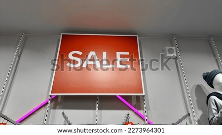 The sale inscription is on a red sign in the store. focus on the inscription. the concept of holiday shopping.