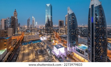 Aerial panoramic view of Dubai International Financial District with many skyscrapers night after sunset. Traffic on a road near parking lot at shopping avenue walking area. Dubai, UAE. Royalty-Free Stock Photo #2273979833