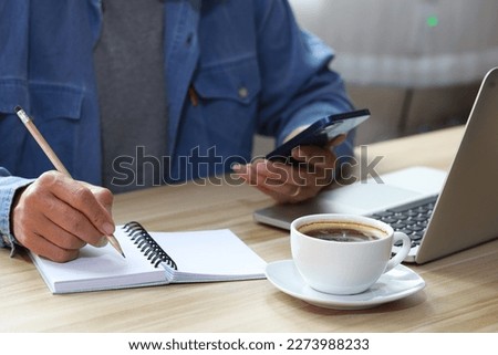 smart businessman with red shirt and working with laptop smartphone while working on his project