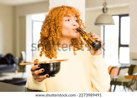 young red hair latin pretty woman eating ramen noodle bowl at home