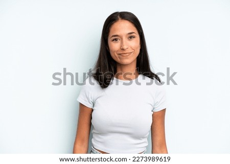 hispanic pretty woman smiling positively and confidently, looking satisfied, friendly and happy
