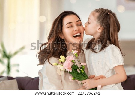 Happy mother's day. Child daughter congratulating her mother and giving her bouquet of flowers. Royalty-Free Stock Photo #2273996241