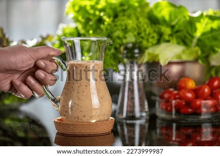 homemade sauces of salad dressings and olive oil in small glass jug including Japanese sesame seed. Glass jug of Japanese sesame seed salad dressings and olive oil. Royalty-Free Stock Photo #2273999987
