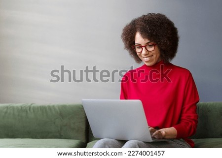 Smiling woman freelancer, copywriter typing on keyboard, using laptop working online from home. Stylish businesswoman wearing red eyeglasses planning startup in modern office. Successful business  