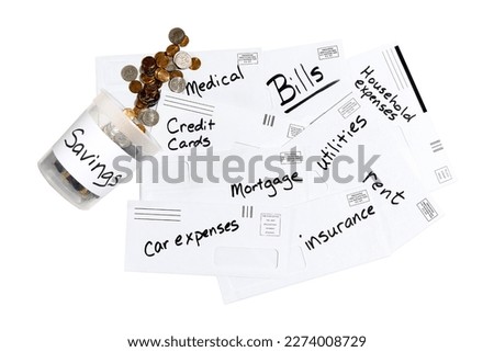 Plastic savings container with coins spilling out over a pile of envelopes with household expenses. White background with copy space.