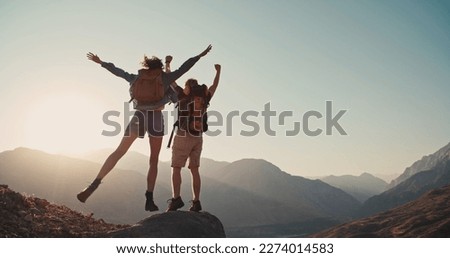 Travel concept with happy couple at mountain top with raised arms and islands at background. Place for text.  Royalty-Free Stock Photo #2274014583