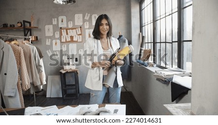  Modern Happy smiling Young attractive Asian woman or female professional fashion stylist standing in a designer office and looking at the camera. self-employment and startup concept.