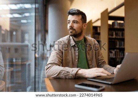 Portrait of attractive businessman, using laptop, hispanic man working online. Middle aged hipster guy working in modern office, looking away. Successful programmer sitting at desk  Royalty-Free Stock Photo #2274014965
