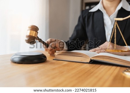 Lawyer, legal consultant, businesswoman reading a law book And holding a hammer to knock for deals, advice, justice in real estate business at office.