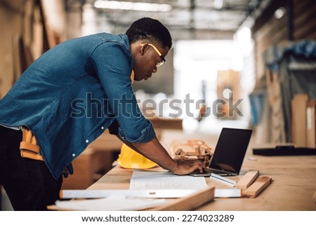 Portrait african american man carpenter craftman working in wood factory, small business wood workshop. Timber industry and furniture factory. Royalty-Free Stock Photo #2274023289