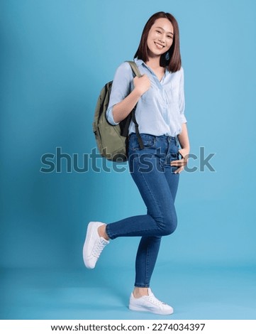 Young Asian student on blue background Royalty-Free Stock Photo #2274034397