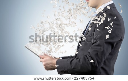 Businessman is using a tablet with flying letters.  