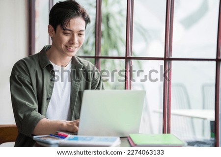 Young Asian businessman working at coffee shop Royalty-Free Stock Photo #2274063133