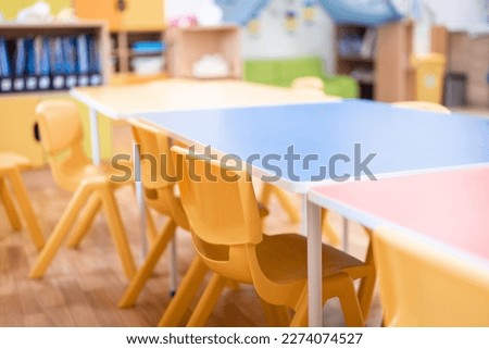Colorful kindergarten class without childs ,school education desk, chair, toy and decoration on background wall. Childhood.