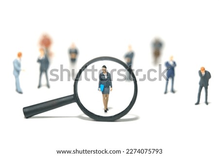 Miniature people toy figure photography. Women leader search. A businesswoman standing in the middle of male people crowd with magnifier glass. Isolated on white background. Image photo
