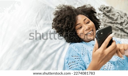 Black African woman with attractive smile use tablet smartphone on white bed, Portrait beauty girl relax in bedroom. Technology people connection digital online marketing e-commerce concept banner