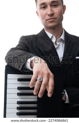Studio portrait of a man playing at piano and smiling isolated on white background