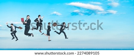 Group of businesspeople jumping in front of blue sky. Success of business.