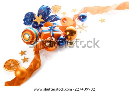 Colorful orange, gold and blue Xmas background over white with copyspace in a corner arrangement of baubles, ribbon, star, bow and gifts