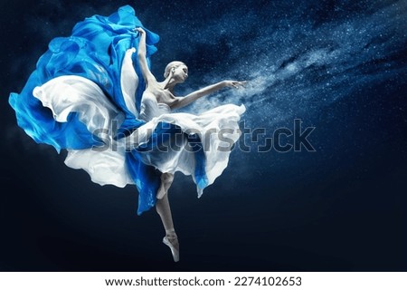 Ballerina dancing in Blue Chiffon Dress over Night Sky Background. Ballet Dancer jumping in fluttering Skirt pointing towards Hand. Fantasy Woman as Antique Goddess Royalty-Free Stock Photo #2274102653