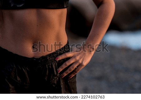 Close up of woman belly with abs abdominal and black sportswear. Concept of healthy body active lifestyle people and diet results. Active life body conscious muscles and health food nutrition Royalty-Free Stock Photo #2274102763