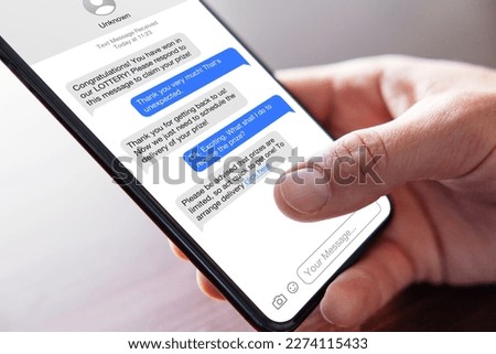 Person reading scam messages on mobile phone Royalty-Free Stock Photo #2274115433