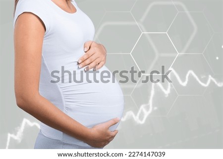 Happy pregnant woman with chart of hormone level Royalty-Free Stock Photo #2274147039