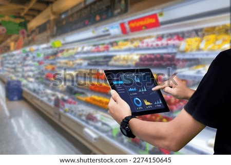 Smart retail management system.Worker hands holding tablet on blurred supermartket as background