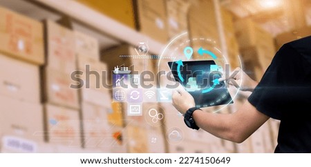 Business Logistics technology concept.Manager hands using tablet on blurred warehouse with full of boxes as background