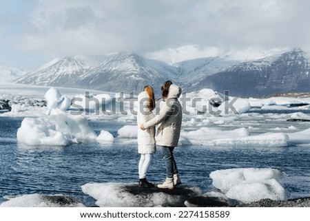 a couple on the background of glaciers are hugging