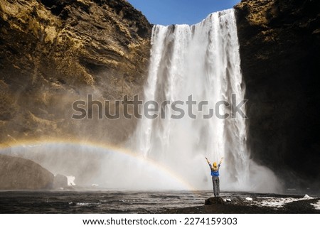 a girl on a background of a giant waterfall with a rainbow in Ic
