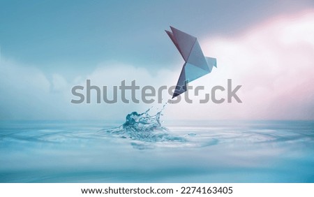 Peace concept. Conceptual photos to show the Freedom of White Origami Dove or Pigeon Flew from the Water into the Sky. International World Peace day, Human Rights, Love and Hope Royalty-Free Stock Photo #2274163405