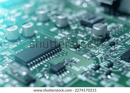 Closeup of Printed Circuit Board with processor, integrated circuits and many other surface mounted passive electrical components. Royalty-Free Stock Photo #2274170215