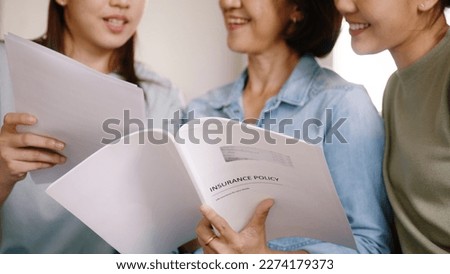 Buy mediclaim health care life insure for older mum. Young adult woman asia people grown up child give gift to middle aged mom reading protect cover saving plan paper smile laugh sitting at sofa home. Royalty-Free Stock Photo #2274179373