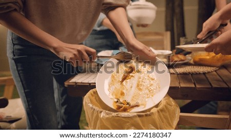 Group of people party at home after meal eating throw away leftovers food to plastic bag junk trash bin. Net zero waste go green eco friendly lifestyle reduce household scrap. Save the planet earth. Royalty-Free Stock Photo #2274180347