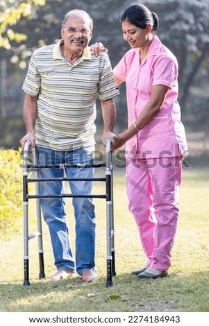 Young Asian woman nurse care giver helping senior old man with mobility walker in garden at home