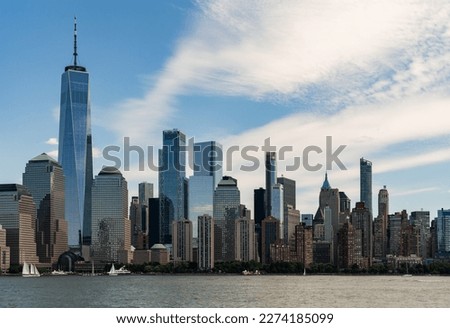 New York skyline, office skyscrapers under cloudy sky, waterfront and financial corporation. Manhattan cityscape and world trade center