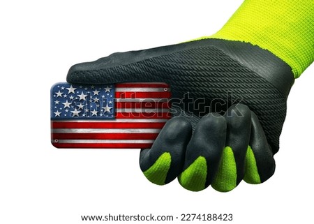 Manual worker with protective work glove holding a small wooden national flag of the United States of America, USA (American flag), isolated on white background.