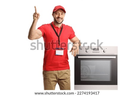 Salesman leaning on an oven and pointing up isolated on white background